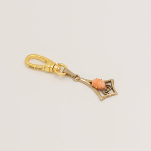 Articulated geometric charm with coral cabochon
